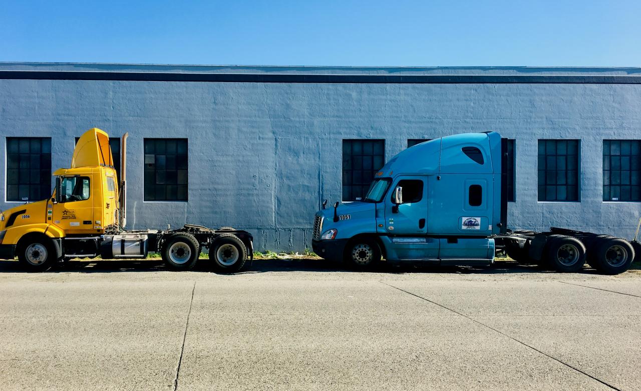 two semi trucks parked in front of a building