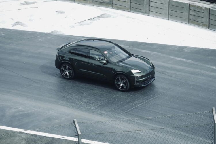 Sebuah mobil hitam melaju di jalan di sebelah pagar